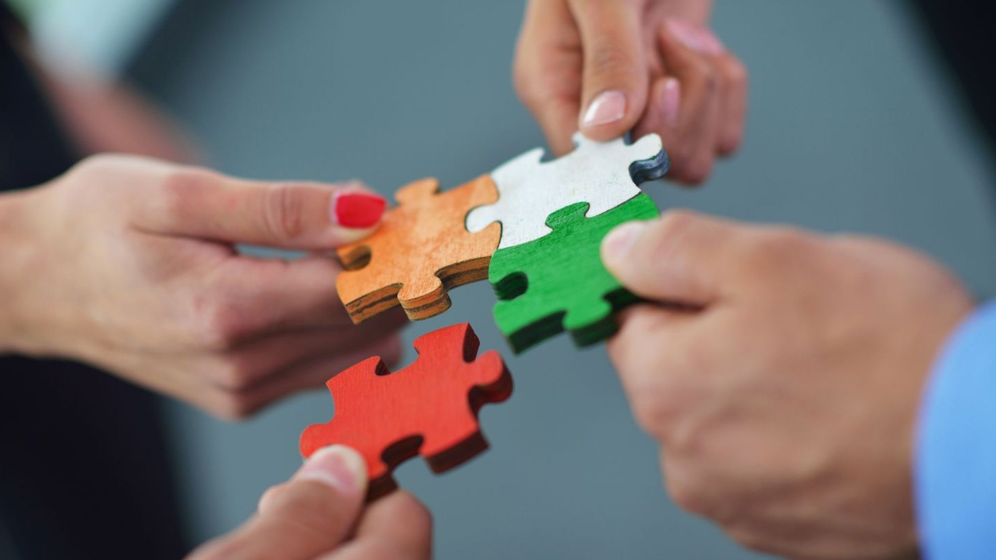 A group of employees making puzzle pieces while discussing business operations and CRM solutions