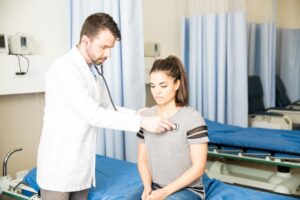 male-doctor-using-stethoscope-check-breathing-female-patient-hospital