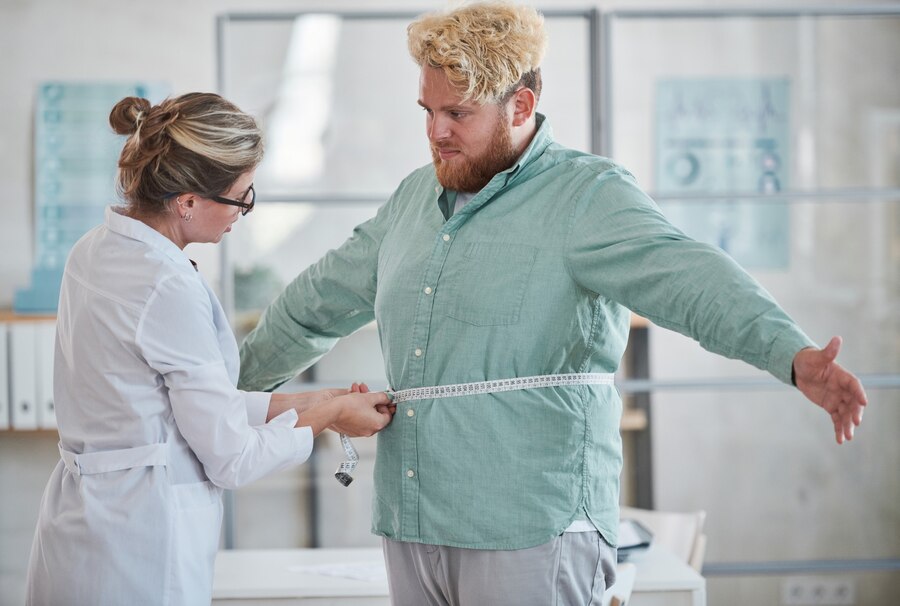 young-nutritionist-measuring-overweight-man-with-centimeter-tape-prescribing-diet