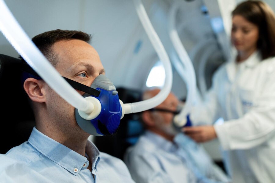 mid-adult-man-breathing-through-mask-hyperbaric-oxygen-therapy-clinic