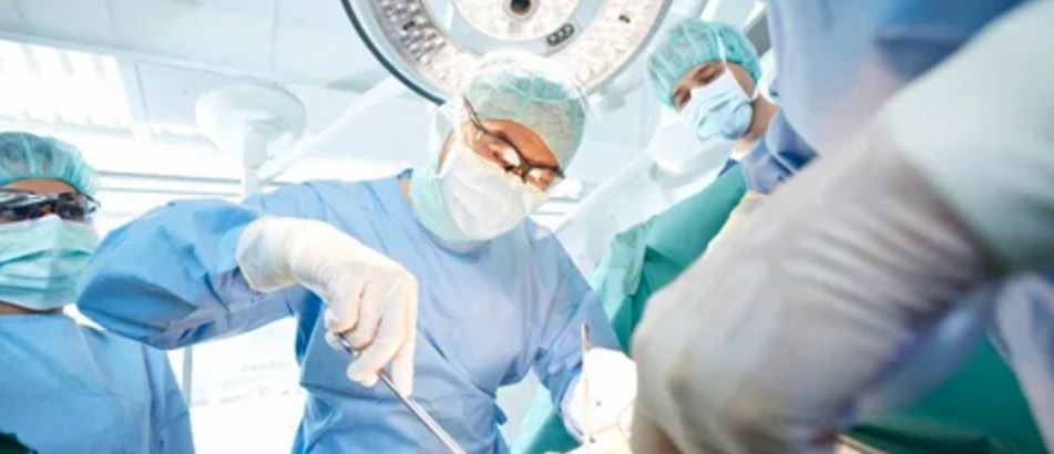 Surgeons diligently performing a surgical procedure in a sterile operating room environment.