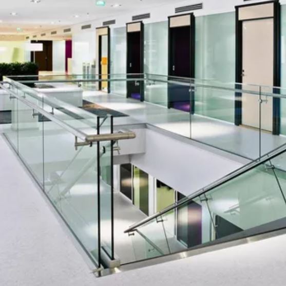 A modern glass stairway elegantly connects multiple floors in a contemporary office building.