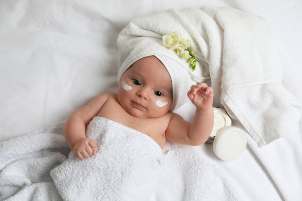 Cute little baby with cream on face, top view