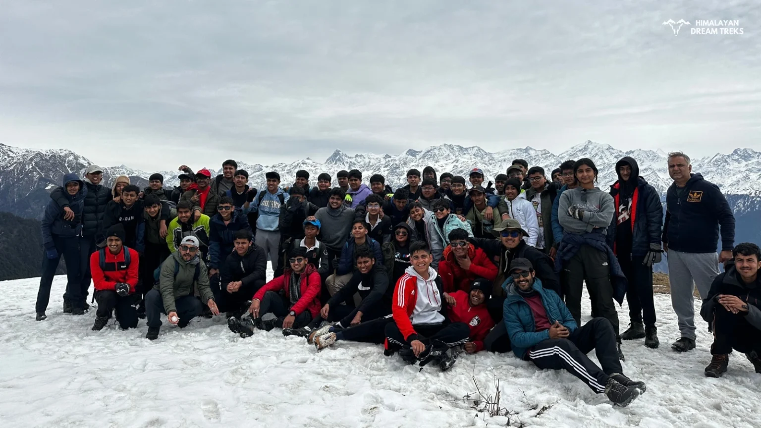 Trekkers making their way through the snow-covered trails of Dayara Bugyal in winter.